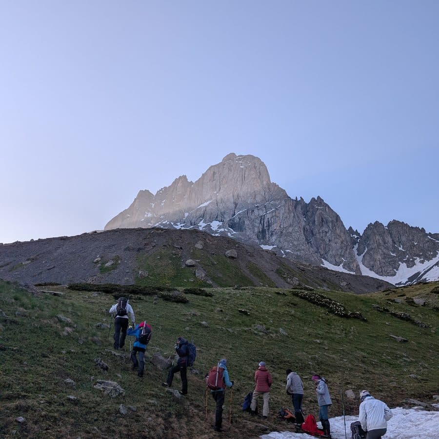 An Adventure Experts Georgia guide leading a small group of travellers below the Chaukhi peaks