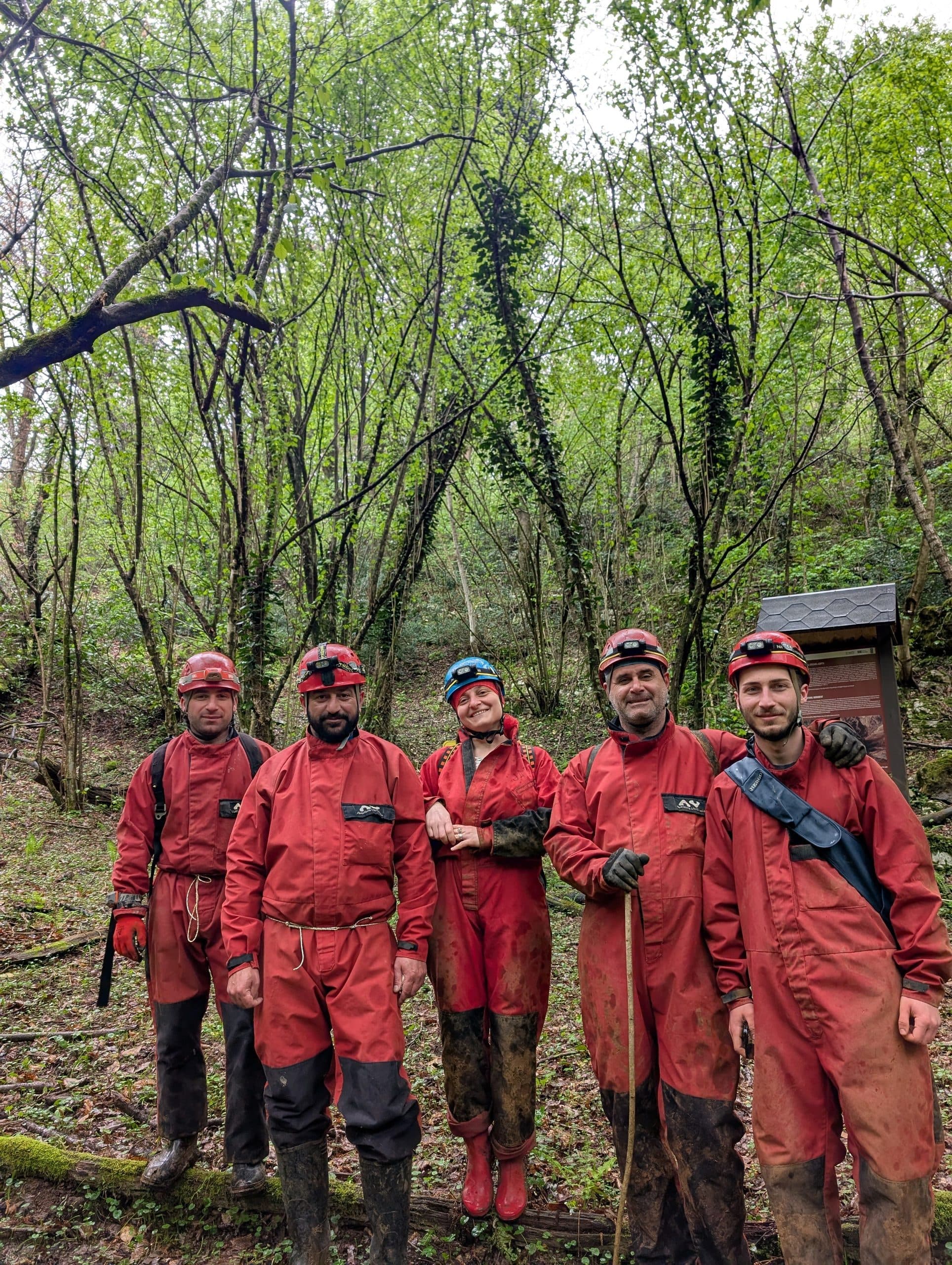 The group geared up in caving suits at the forest cave entrance