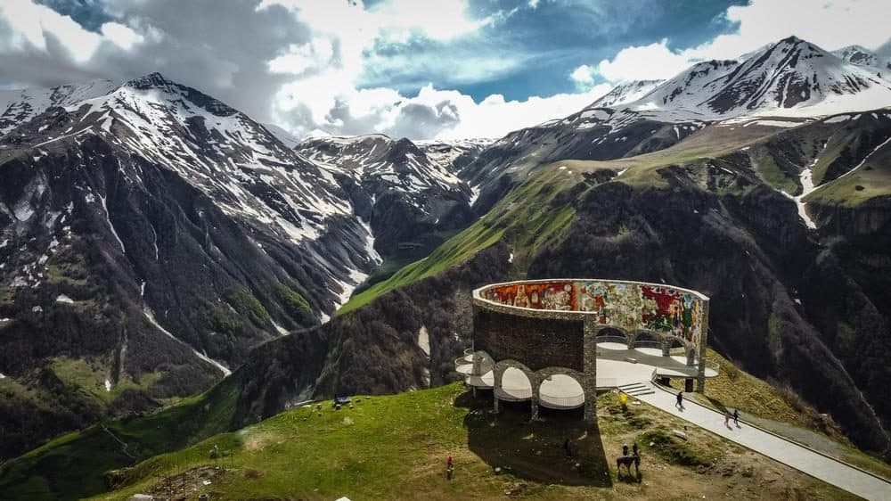 The Russia–Georgia Friendship Monument at Gudauri, ringed by snowy peaks